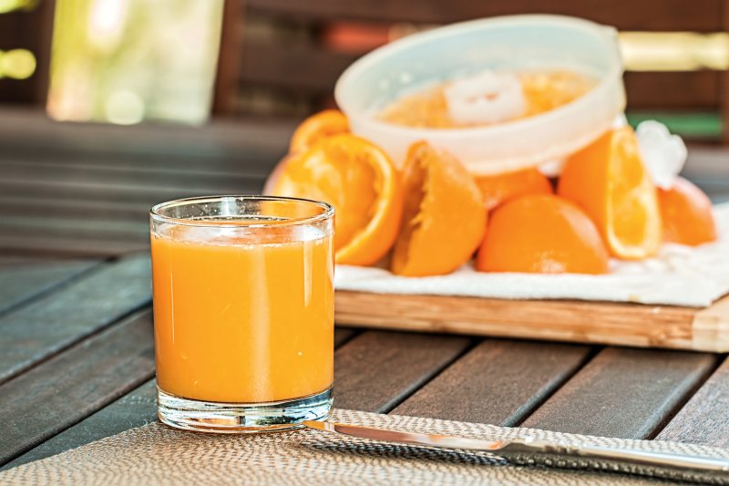 Orangensaft mit Orangen im Hintergrund