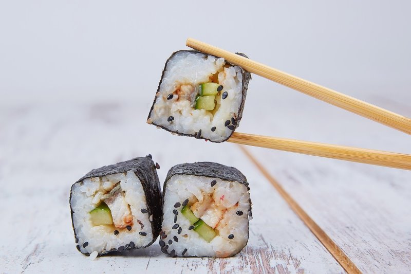 Essstäbchen aus Holz greifen Sushi