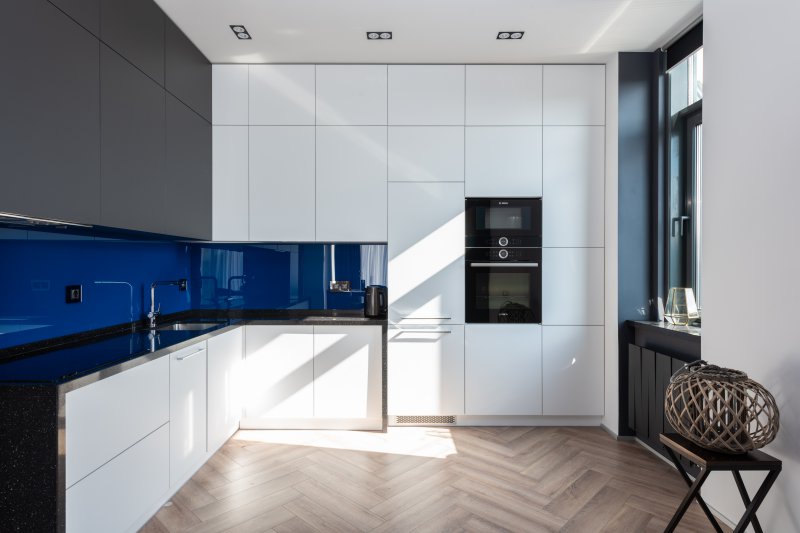Bild auf dem ein autarker Backofen in einer weißen Küche mit blauen Elementen zu sehen ist.