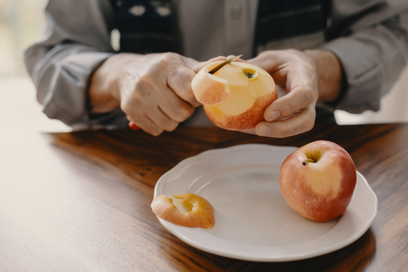 Apfel wird mit einem Messer geschält